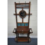 AN ARTS AND CRAFTS MAHOGANY HALL STAND, with six brass hooks, circular bevelled mirror, blue