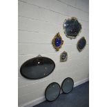 AN OVAL GILT FRAMED BEVELLED EDGE WALL MIRROR, and four foliate framed wall mirrors, and two