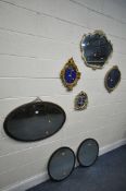AN OVAL GILT FRAMED BEVELLED EDGE WALL MIRROR, and four foliate framed wall mirrors, and two