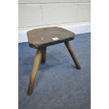 AN ANTIQUE ELM MILKING STOOL (condition:-replacement front two legs)