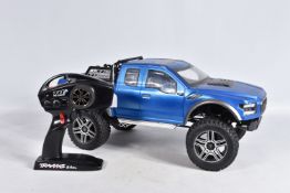 A TRAXXAS REMOTE CONTROLLED FORD PICKUP TRUCK, heavy built frame, blue painted body with black and