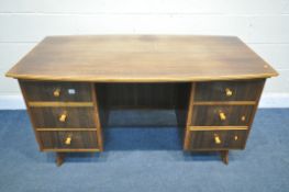 A MID CENTURY TEAK DESK, possibly Morris of Glasgow, bow front and back top, over six drawers, width
