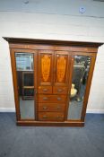 AN EDWARDIAN MAHOGANY COMPACTUM WARDROBE, with two bevelled mirror doors, flanking two small