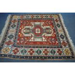A LATE 19TH/EARLY 20TH CENTURY KAZAK WOOLLEN RUG, with a central medallion, red field, and a