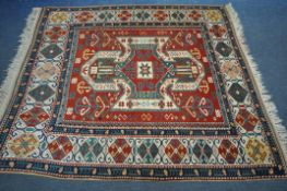 A LATE 19TH/EARLY 20TH CENTURY KAZAK WOOLLEN RUG, with a central medallion, red field, and a