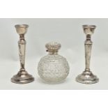 A PAIR OF ELIZABETH II SILVER CANDLESTICKS AND AN EDWARDIAN SILVER MOUNTED GLASS SCENT BOTTLE, the