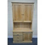 A LIGHT OAK DRESSER, top section with double panelled doors, over a base with three drawers,