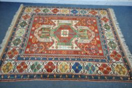 A LATE 19TH/EARLY 20TH CENTURY KAZAK WOOLLEN RUG, with a central medallions, red field, and