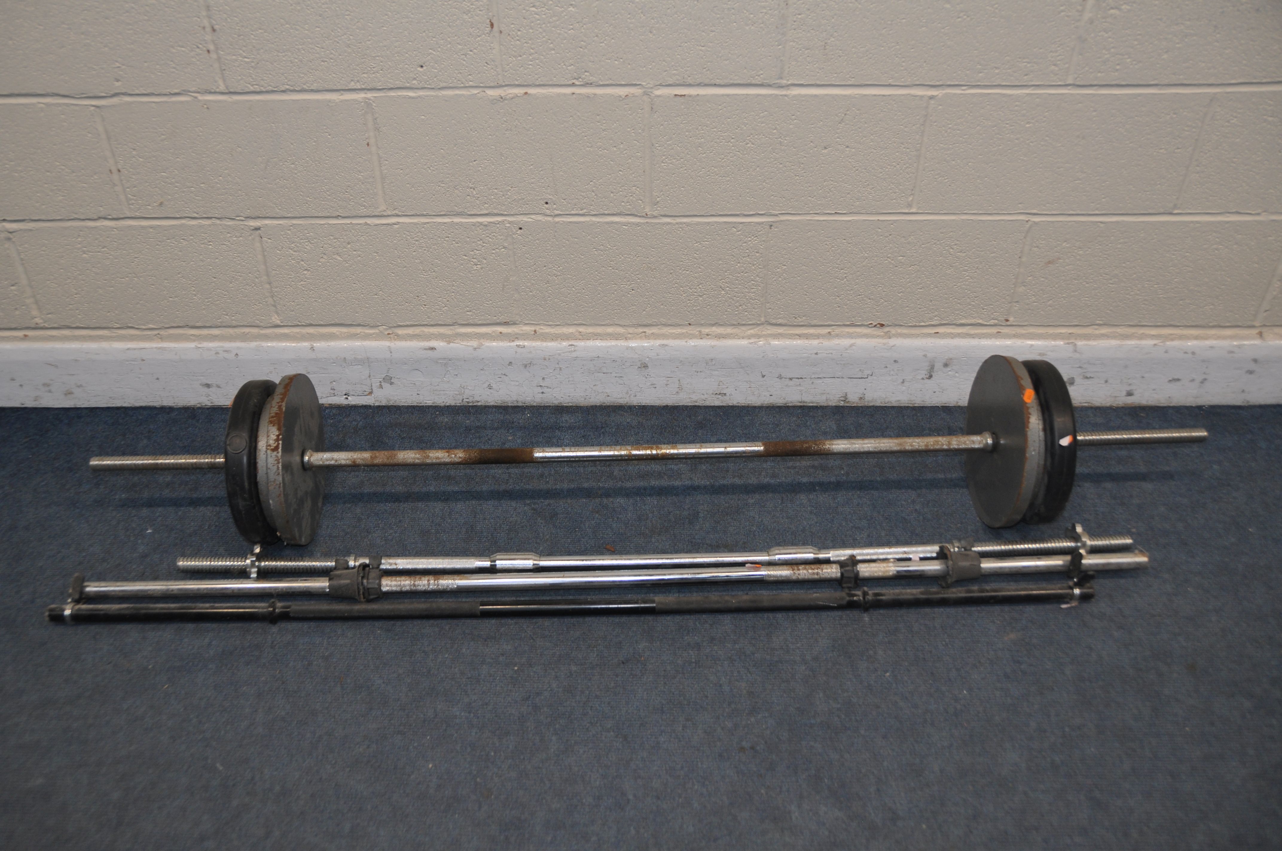 A COLLECTION OF WEIGHTLIFTING EQUIPMENT to include four barbells and a selection of weights to