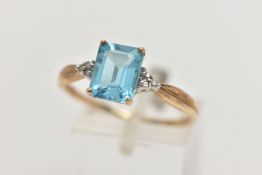 A 9CT GOLD TOPAZ AND DIAMOND RING, designed with a rectangular cut light blue topaz, in a four