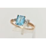 A 9CT GOLD TOPAZ AND DIAMOND RING, designed with a rectangular cut light blue topaz, in a four