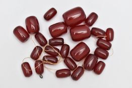 A SMALL BAG OF LOOSE CHERRY AMBER BAKELITE BARREL BEADS, graduated oval beads, visible swirls