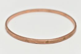 A ROSE METAL BANGLE, hollow bangle with an engine turned pattern, stamped 9ct, internal diameter