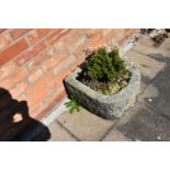 A VINTAGE SANDSTONE TROUGH with one curved end width 46cm depth 52cm height 30cm with soil and