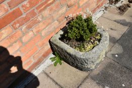 A VINTAGE SANDSTONE TROUGH with one curved end width 46cm depth 52cm height 30cm with soil and