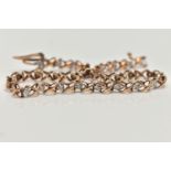 A 9CT GOLD LINE BRACELET, a rose gold cross link bracelet, interspaced with round brilliant cut