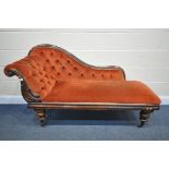 A VICTORIAN MAHOGANY CHAISE LONGUE, with red buttoned fabric, on turned legs and ceramic casters,