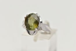A 9CT WHITE GOLD, TOURMALINE AND DIAMOND RING, designed with an oval cut green tourmaline in a