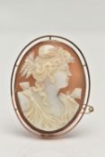 A CAMEO BROOCH, oval carved shell cameo depicting a lady in profile, collet set in a rose metal