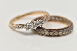 TWO YELLOW METAL RINGS, the first a three stone diamond ring, set with a central round brilliant cut