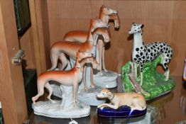 FOUR VICTORIAN STAFFORDSHIRE POTTERY FIGURES OF DOGS STANDING WITH HARES AND A PEN HOLDER, three