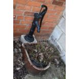 A VINTAGE TREACLE GLAZED TROUGH with one curved end depth 57cm, a vintage water pump and a stone