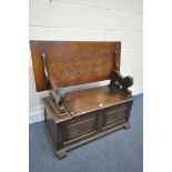 A 20TH CENTURY MONKS BENCH, lifting lid supported by lion mask uprights, surrounding storage