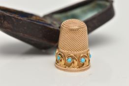 A YELLOW METAL THIMBLE, foliage pattern round the rim set with turquoise cabochons, unmarked,
