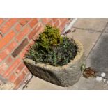 A VINTAGE SANDSTONE TROUGH with one curved end width 43cm depth 54cm height 28cm with soil and