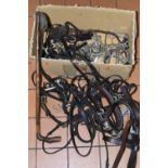 ONE BOX OF LEATHER HORSE BRIDLES, STIRRUPS, BITS AND WHIPS, to include solid nickel bits, maker's