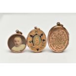 TWO EARLY 20TH CENTURY LOCKETS AND A PHOTO PENDANT, the first an oval yellow metal locket with