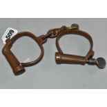 A PAIR OF COPPER HIATT HANDCUFFS COMPLETE WITH KEY, both locks are functioning