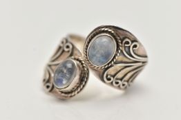 A SILVER MOONSTONE DRESS RING, of a cross over design, set with two oval moonstone cabochons, each
