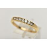 AN 18CT GOLD DIAMOND BAND RING, seven round brilliant cut diamonds, channel set in yellow gold,