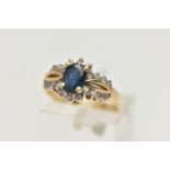 A YELLOW METAL SAPPHIRE AND DIAMOND RING, designed with an oval cut blue sapphire in a four claw