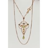 A YELLOW METAL LAVALIER PENDANT AND CHAIN, openwork pendant set with a central oval cut peridot with