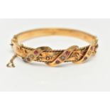 AN EARLY 20TH CENTURY GOLD BANGLE, a hinged bangle designed with foliage and wire work detail, set