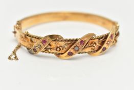 AN EARLY 20TH CENTURY GOLD BANGLE, a hinged bangle designed with foliage and wire work detail, set