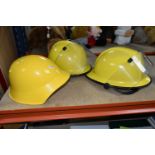 THREE HELMETS, to include a Swiss possibly civil defence helmet painted yellow, and two Cromwell F