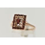 A 9CT GOLD GARNET DRESS RING, rectangular form, set with a principle oval cut garnet and eighteen