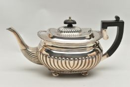 AN EDWARDIAN SILVER TEAPOT OF OVAL FORM, ebony fitments, gadrooned rim, reeded cover and body, on