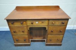 A LATE VICTORIAN WALNUT KNEE HOLE DESK, with a raised back, and seven drawers surrounding a single