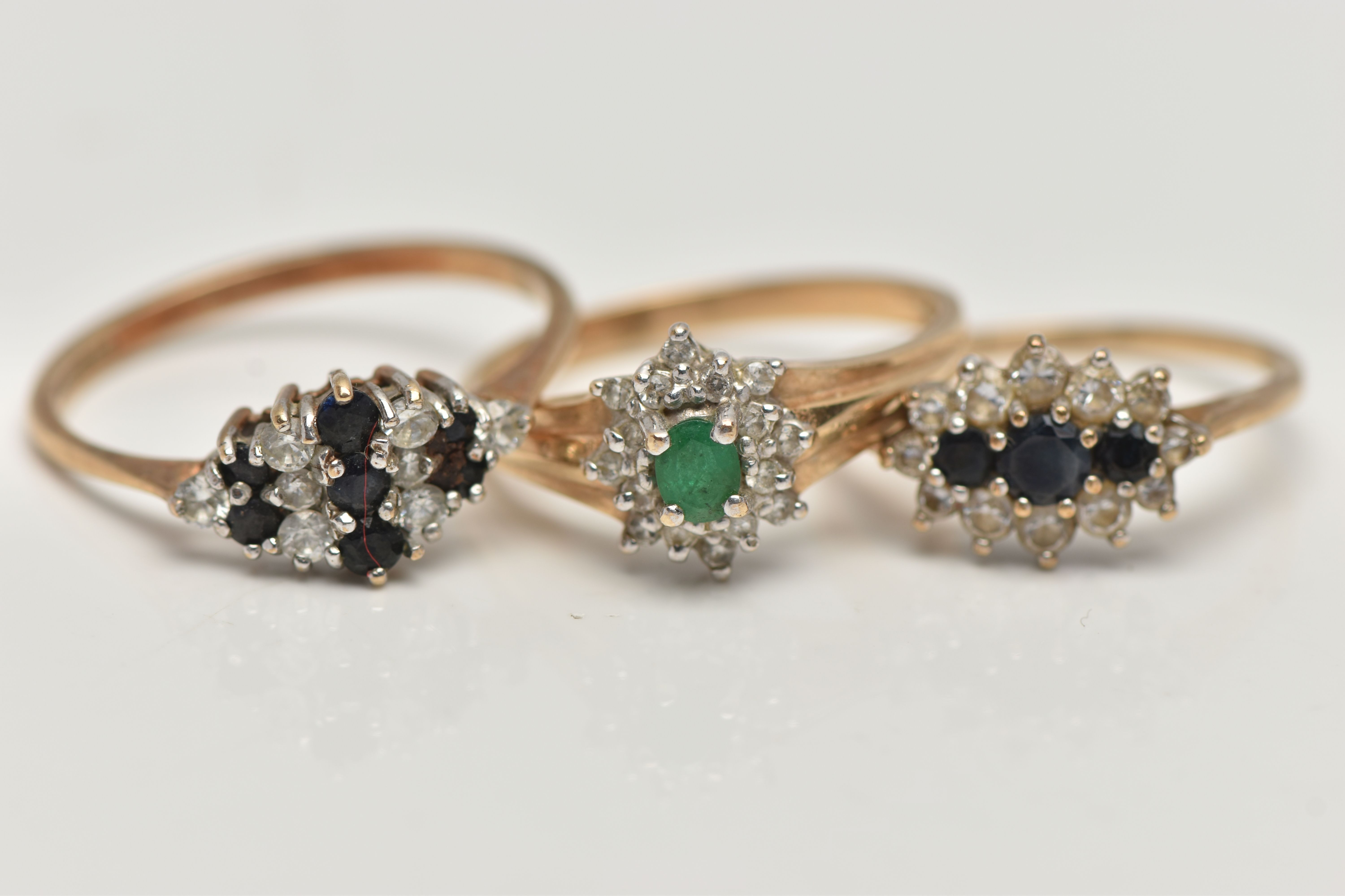 THREE 9CT GOLD GEM SET RINGS, the first a small emerald and diamond cluster ring, hallmarked 9ct