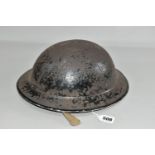 A BRITISH MILITARY STYLE STEEL HELMET, complete with liner and canvas chin strap, distressed black