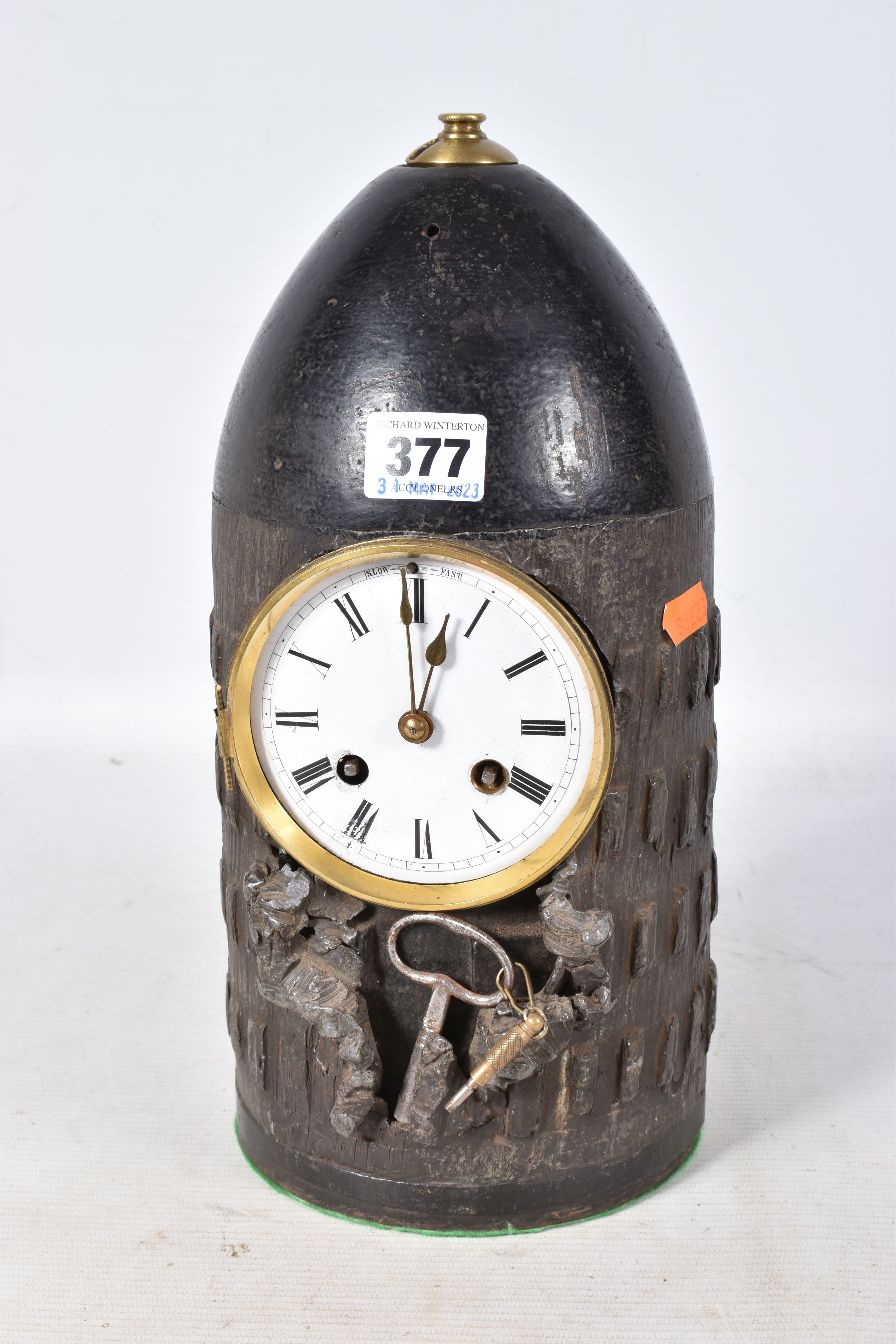 A TRENCH ART MANTLE CLOCK FORMED FROM A BOMB CASING, fitted with a late 19th century enamel dial and