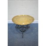 A CIRCULAR BRASS DECORATIVE DISH TOP, on a later scrolled metal base, diameter 60cm x height 46cm (