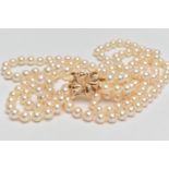 A CULTURED PEARL NECKLACE, designed with three strands of individually knotted cream pearls with a