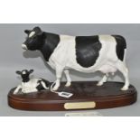 A ROYAL DOULTON FRIESIAN COW AND CALF, standing on a wooden plinth, model no A2607/2690, height