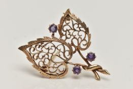 A 9CT GOLD, AMETHYST BROOCH, in the form of two open work leaves, set with three circular cut