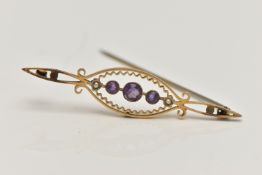 AN EARLY 20TH CENTURY BROOCH, yellow metal open work brooch set with three circular cut amethysts